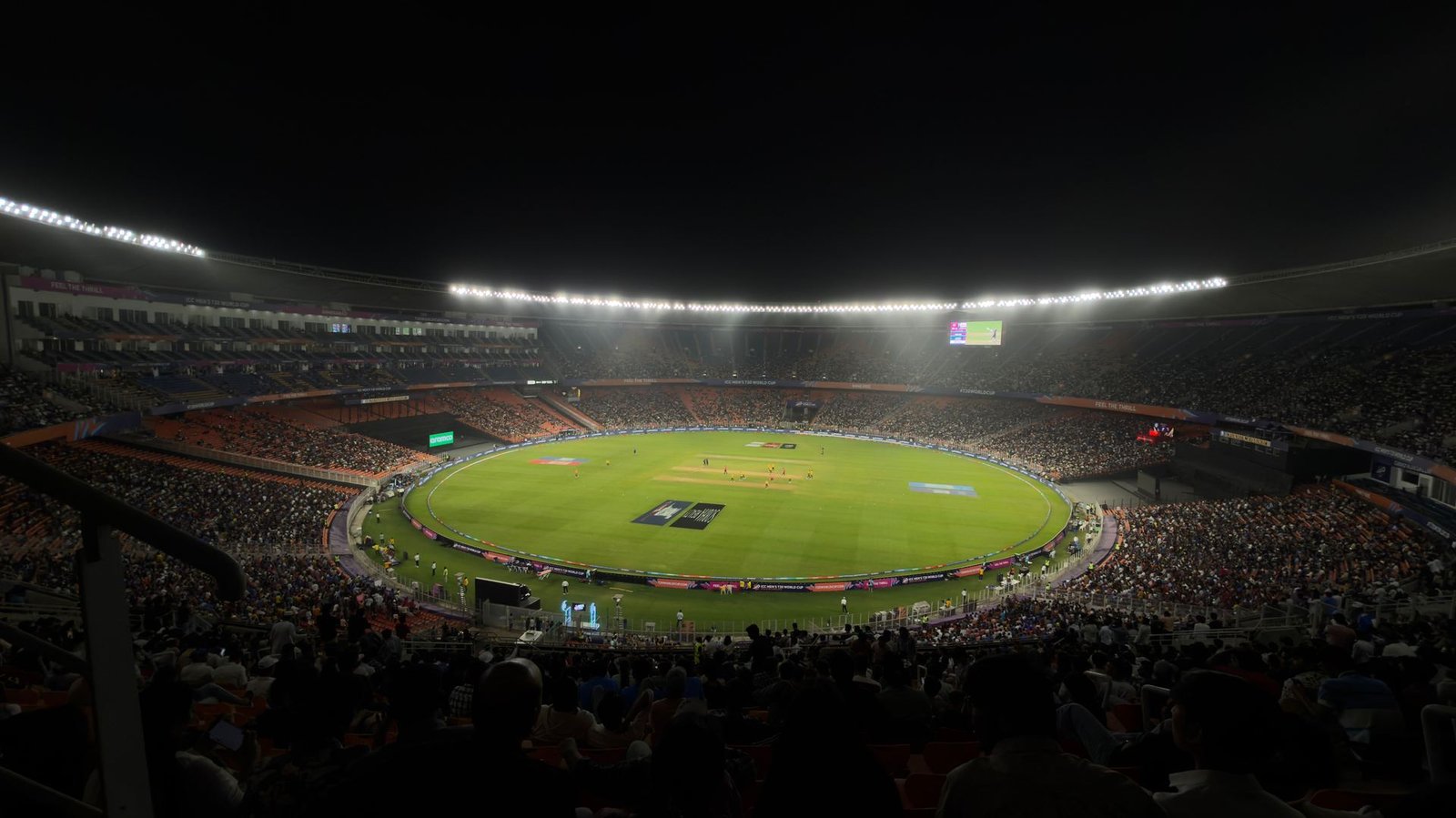 Professional cricket stadium under floodlights